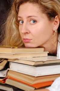 picture of woman with chin propped up on stack of books